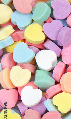 Background of brightly colored candy hearts for Valentine's Day.